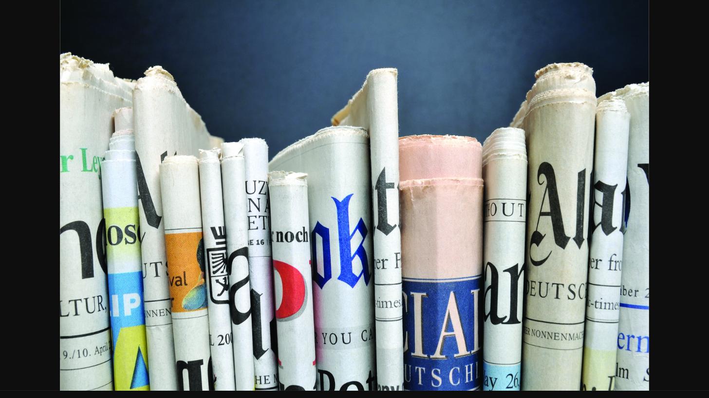 Stack of rolled newspapers representing the AMD London District Newsletter