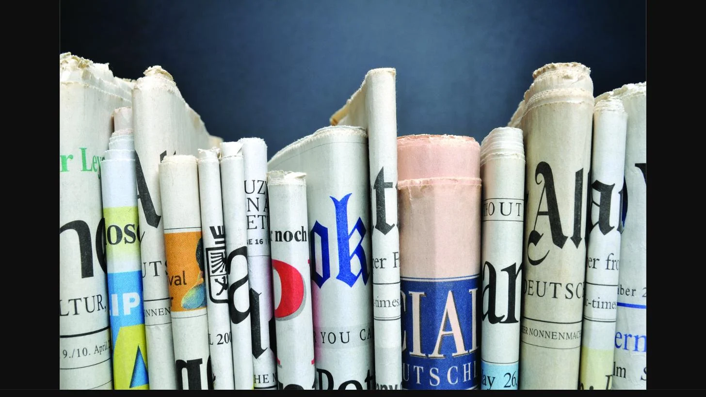 Stack of rolled newspapers representing the AMD London District Newsletter